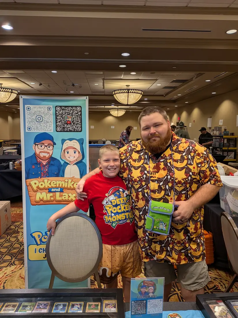 Mike and Mr. Lax at their table at a hotel ballroom card show